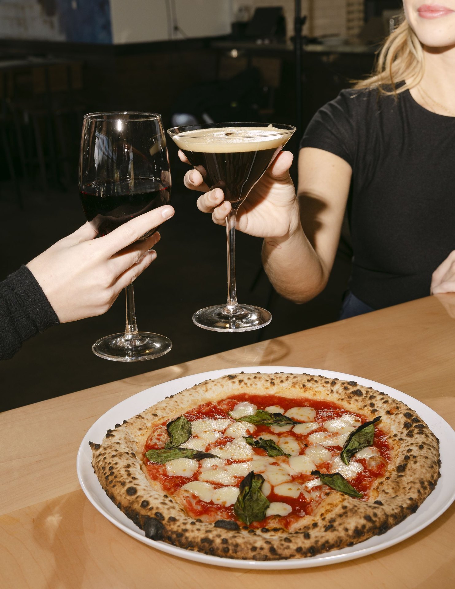 Cheers over a pizza